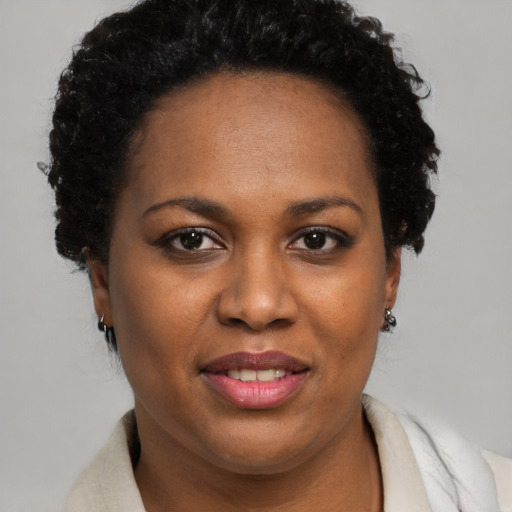 Joyful black adult female with short  brown hair and brown eyes