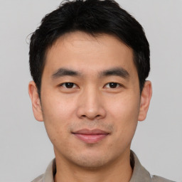 Joyful asian young-adult male with short  black hair and brown eyes