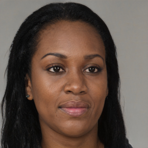 Joyful black young-adult female with long  brown hair and brown eyes