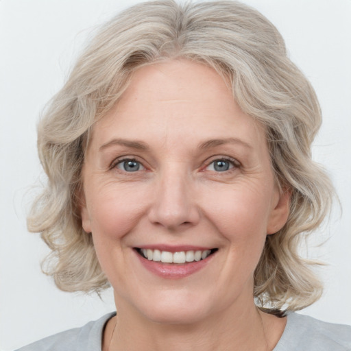 Joyful white adult female with medium  blond hair and grey eyes