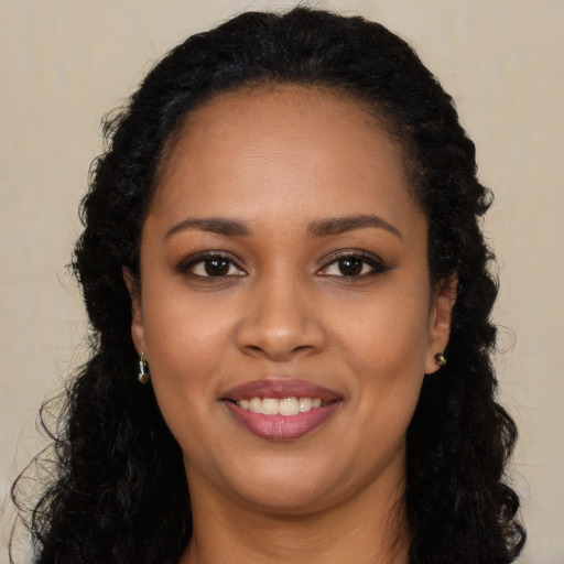 Joyful black young-adult female with long  black hair and brown eyes