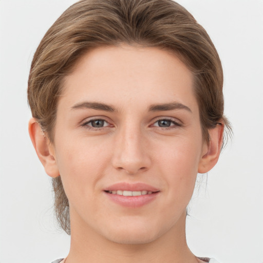 Joyful white young-adult female with short  brown hair and grey eyes