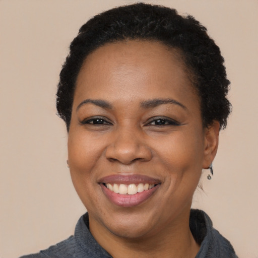 Joyful black adult female with short  black hair and brown eyes