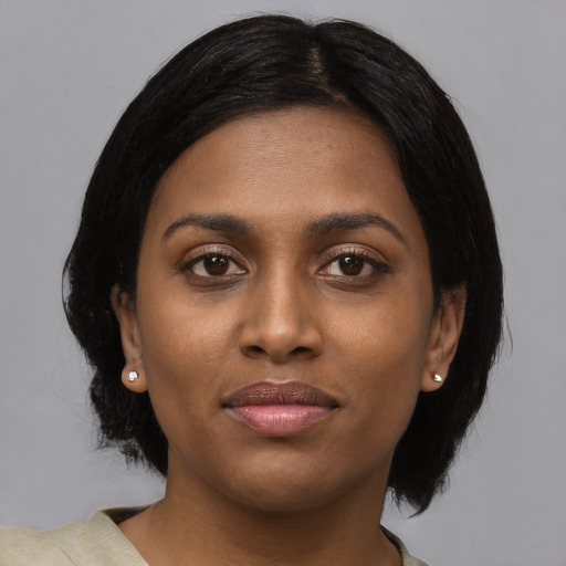 Joyful black young-adult female with medium  black hair and brown eyes