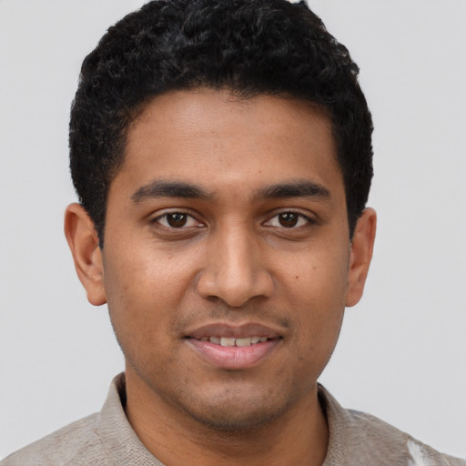Joyful black young-adult male with short  brown hair and brown eyes