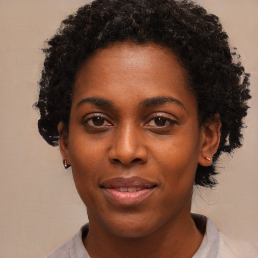 Joyful black young-adult female with short  black hair and brown eyes