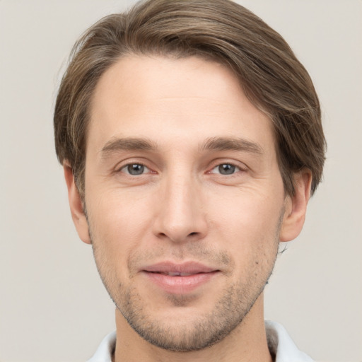 Joyful white young-adult male with short  brown hair and grey eyes