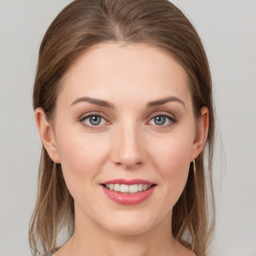 Joyful white young-adult female with medium  brown hair and grey eyes