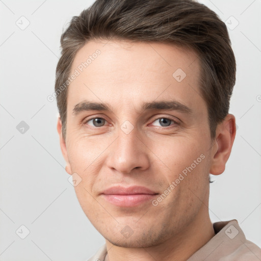 Joyful white young-adult male with short  brown hair and grey eyes