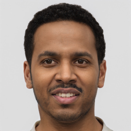 Joyful black young-adult male with short  black hair and brown eyes