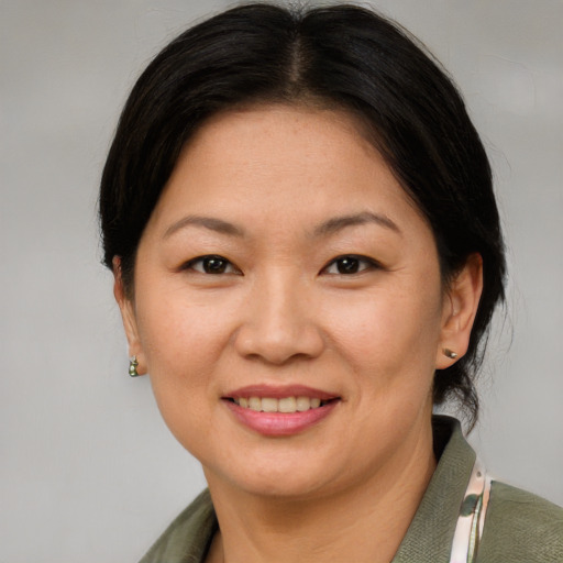 Joyful asian adult female with medium  brown hair and brown eyes