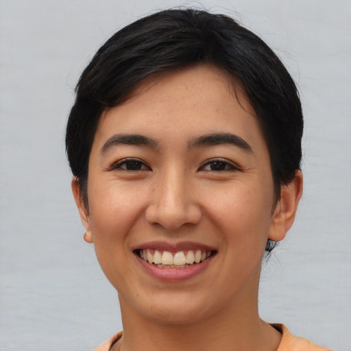 Joyful asian young-adult female with short  black hair and brown eyes