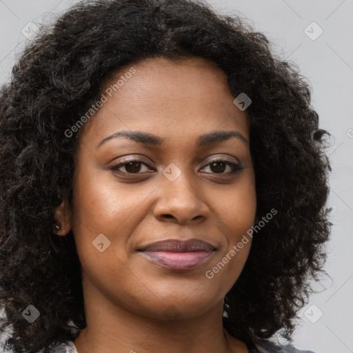 Joyful black young-adult female with long  brown hair and brown eyes