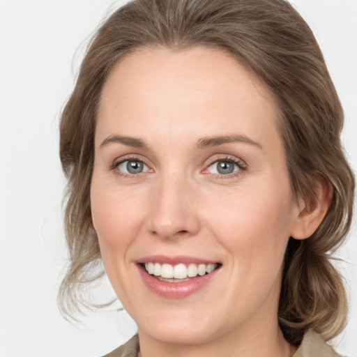 Joyful white young-adult female with medium  brown hair and grey eyes