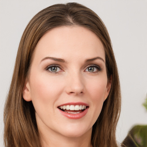 Joyful white young-adult female with long  brown hair and green eyes