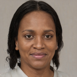 Joyful black adult female with medium  brown hair and brown eyes