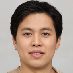 Joyful asian young-adult male with short  brown hair and brown eyes