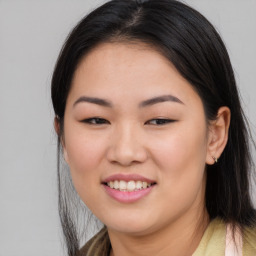 Joyful asian young-adult female with long  brown hair and brown eyes