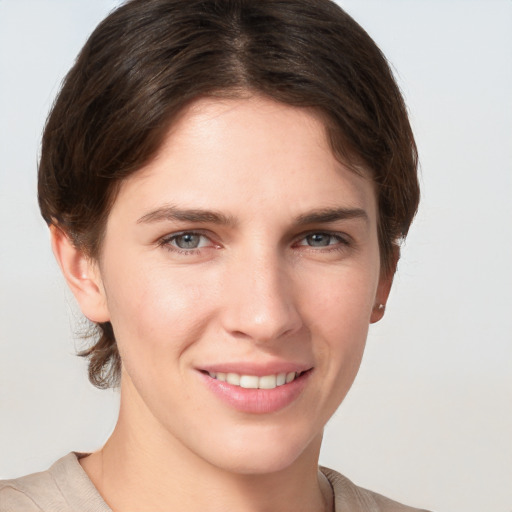 Joyful white young-adult female with medium  brown hair and grey eyes