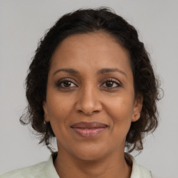 Joyful black adult female with medium  brown hair and brown eyes