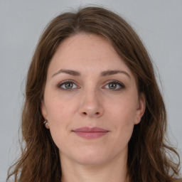 Joyful white young-adult female with long  brown hair and grey eyes