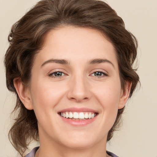 Joyful white young-adult female with medium  brown hair and green eyes