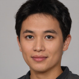 Joyful asian young-adult male with short  black hair and brown eyes