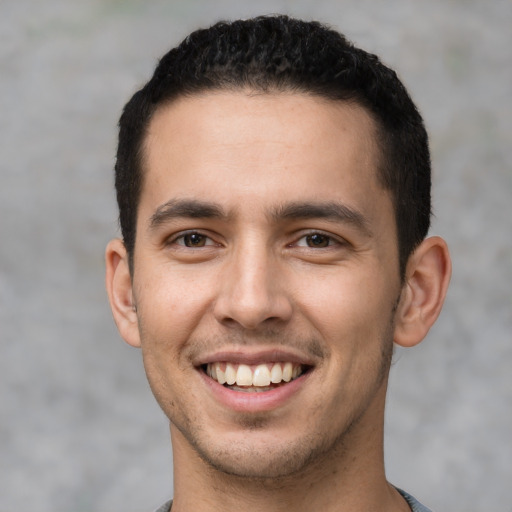 Joyful white young-adult male with short  black hair and brown eyes