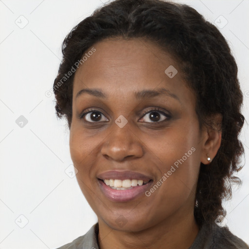 Joyful black young-adult female with long  brown hair and brown eyes