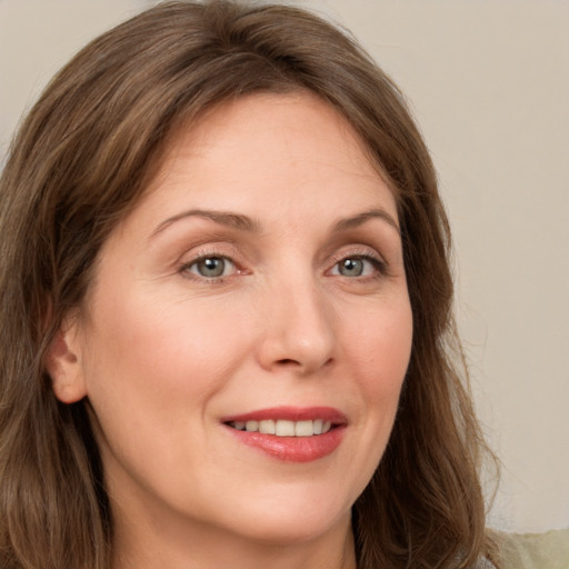 Joyful white young-adult female with long  brown hair and green eyes