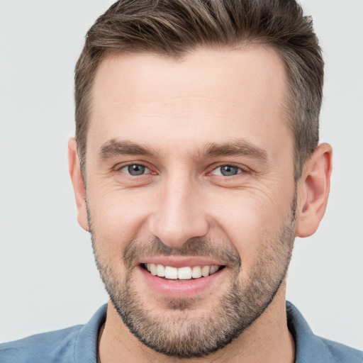 Joyful white young-adult male with short  brown hair and brown eyes