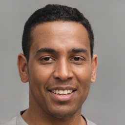 Joyful latino young-adult male with short  brown hair and brown eyes