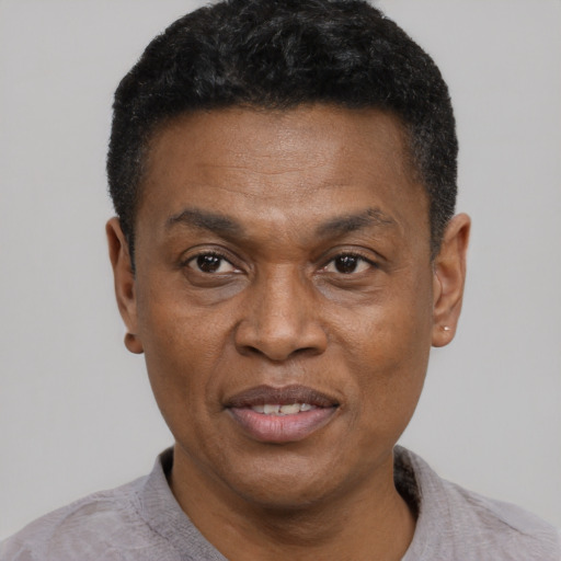 Joyful black adult male with short  black hair and brown eyes