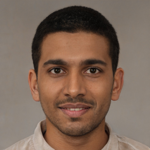 Joyful latino young-adult male with short  brown hair and brown eyes