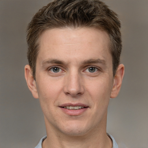 Joyful white adult male with short  brown hair and grey eyes