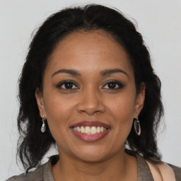 Joyful latino young-adult female with long  brown hair and brown eyes