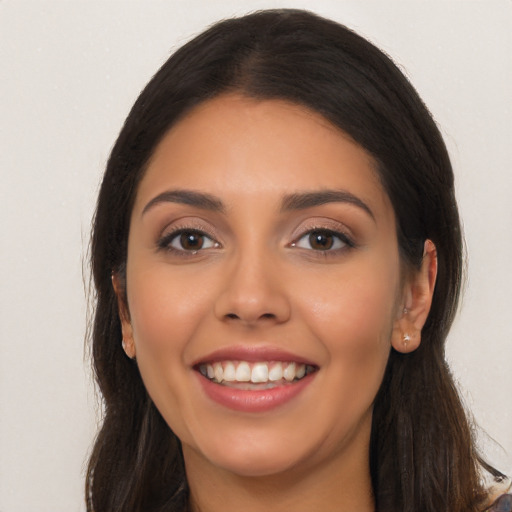 Joyful latino young-adult female with long  brown hair and brown eyes