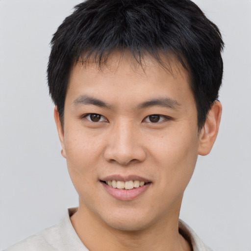 Joyful asian young-adult male with short  brown hair and brown eyes