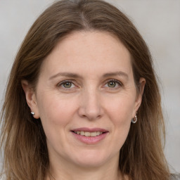 Joyful white adult female with long  brown hair and grey eyes