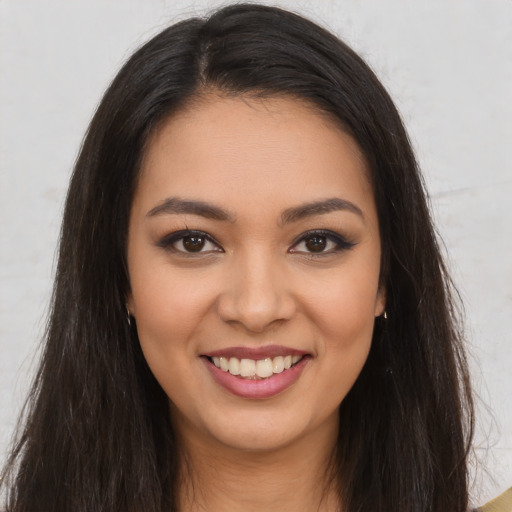 Joyful latino young-adult female with long  brown hair and brown eyes