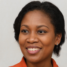 Joyful black young-adult female with long  brown hair and brown eyes