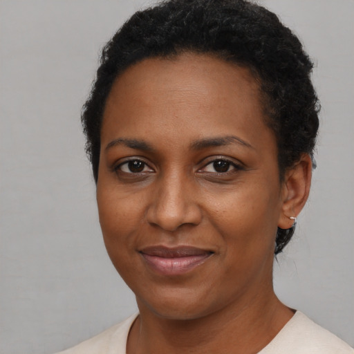 Joyful black young-adult female with short  brown hair and brown eyes