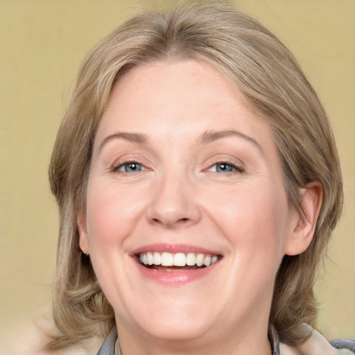 Joyful white adult female with medium  brown hair and grey eyes