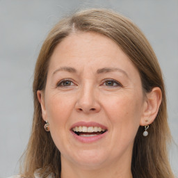 Joyful white adult female with long  brown hair and grey eyes