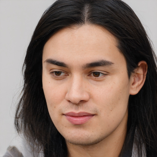 Joyful white young-adult male with long  brown hair and brown eyes