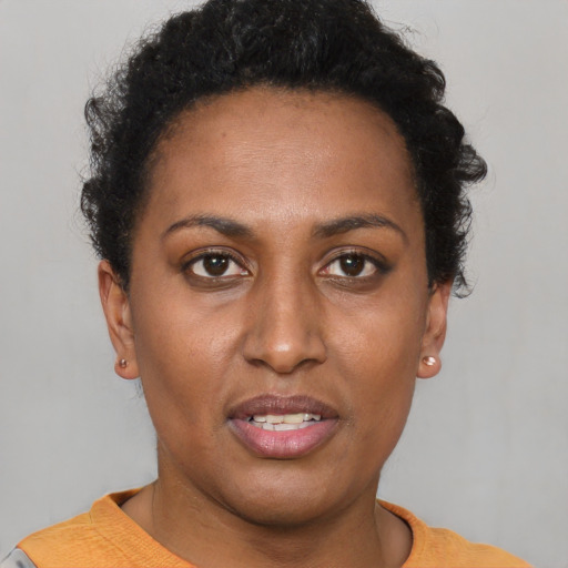 Joyful black young-adult female with short  brown hair and brown eyes