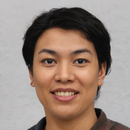 Joyful asian young-adult female with short  black hair and brown eyes