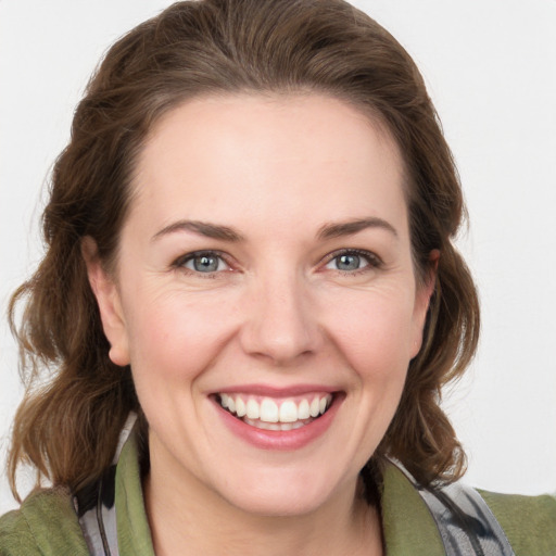 Joyful white young-adult female with medium  brown hair and grey eyes