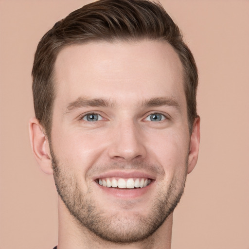 Joyful white young-adult male with short  brown hair and grey eyes