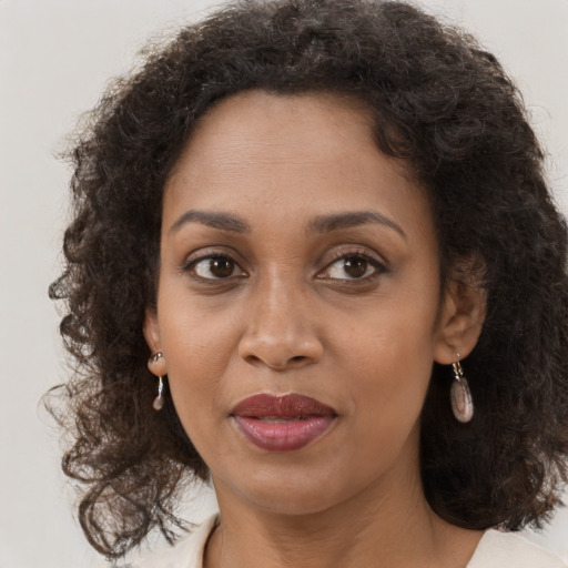 Joyful black adult female with long  brown hair and brown eyes